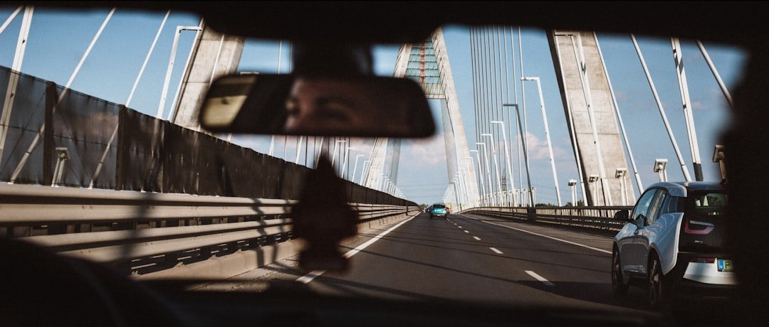 person in blue jacket standing on sidewalk during daytime