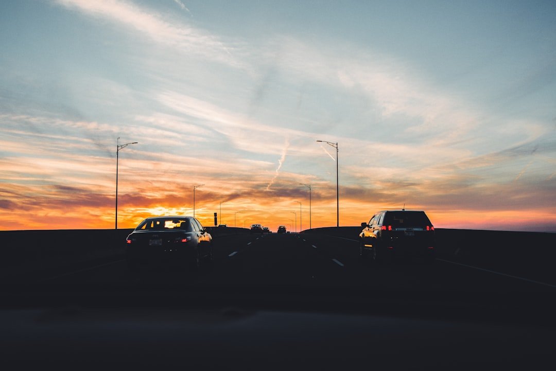 silhouette of cars on road during sunset