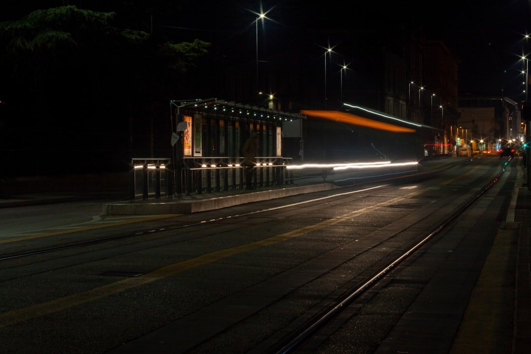 a city street at night with a train on the tracks