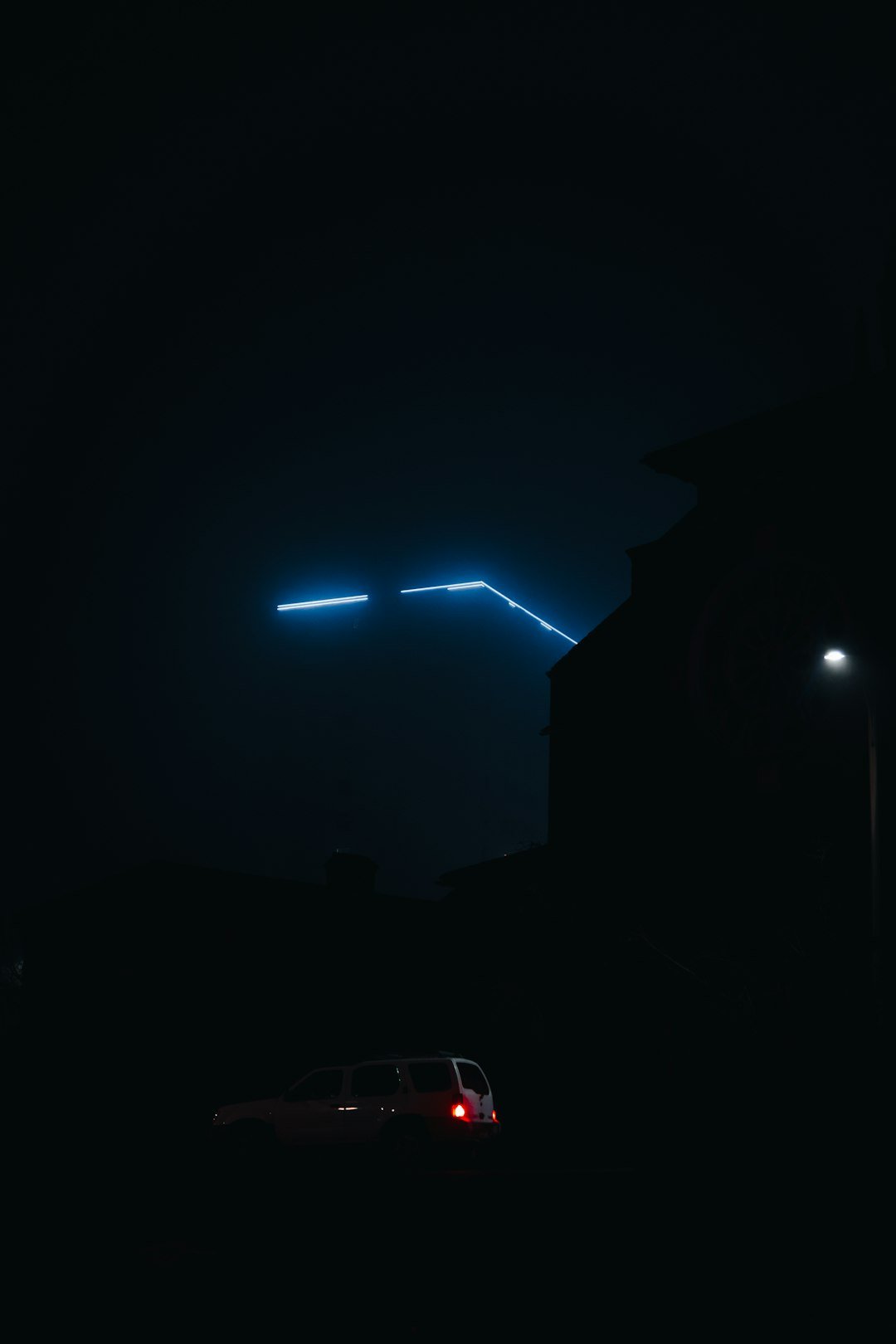 A car is parked in the dark at night