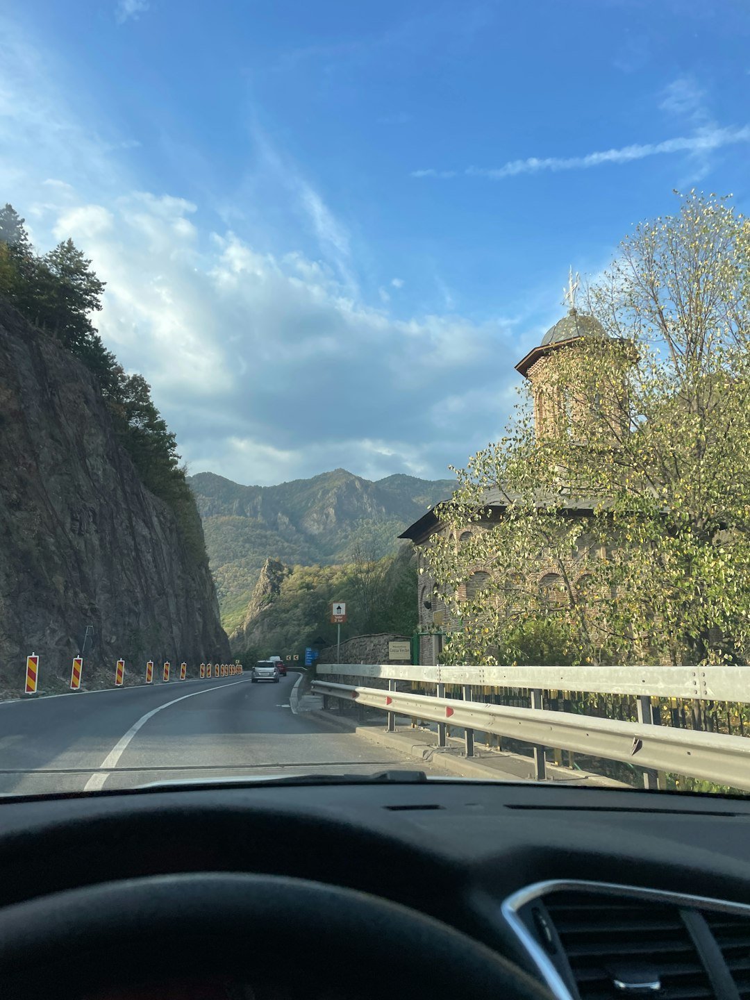 A car driving down a road next to a mountain